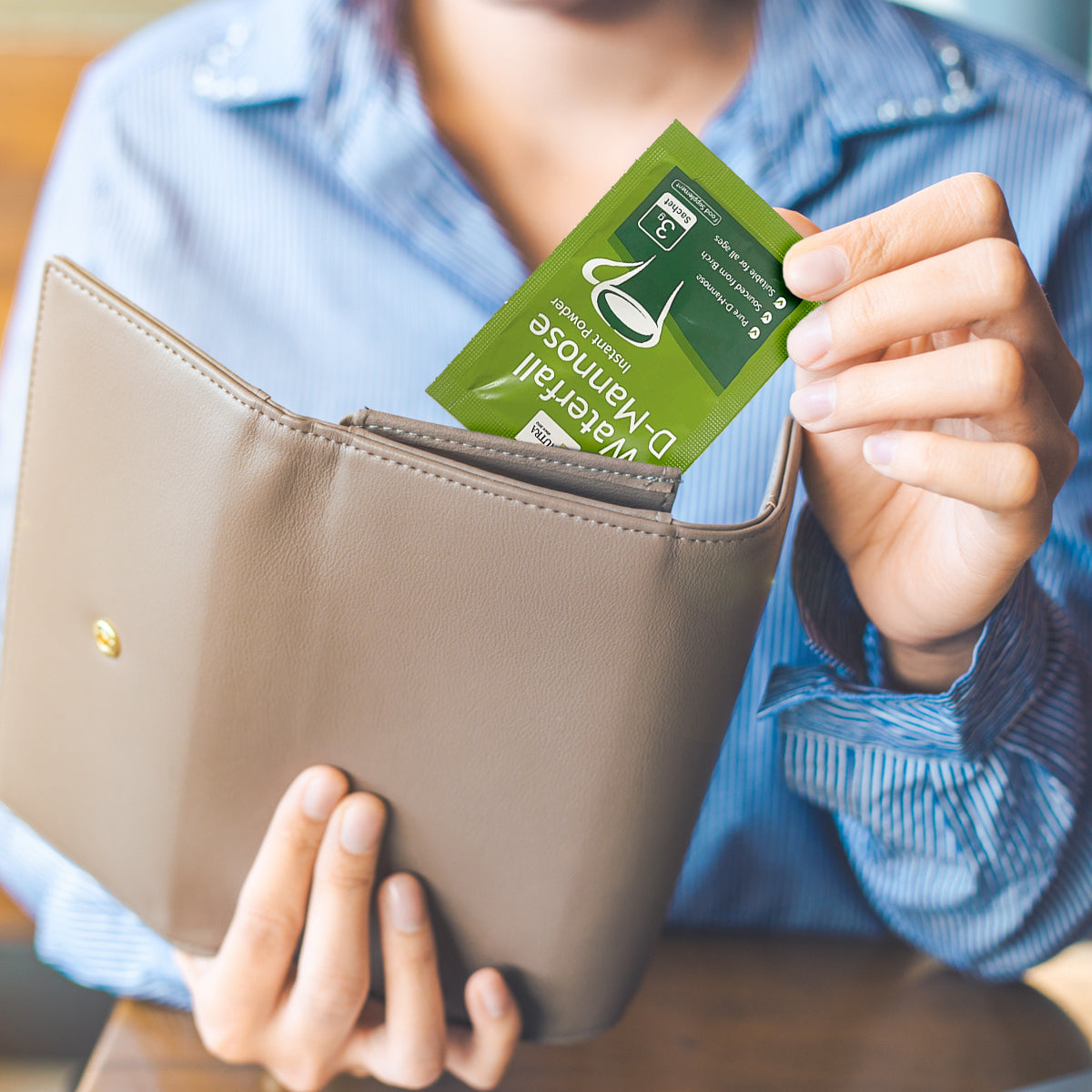 Waterfall D-Mannose sachets lifestyle image showing the credit card sized sachets fitting in to a purse or wallet. 